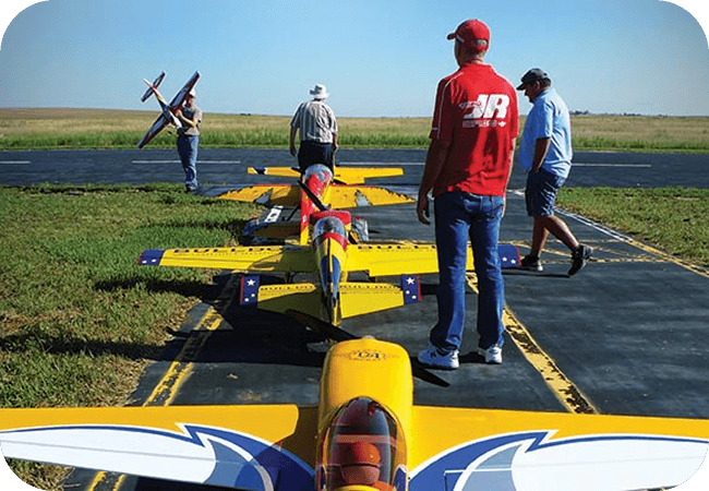 RC hobby enthusiasts with planes on runway